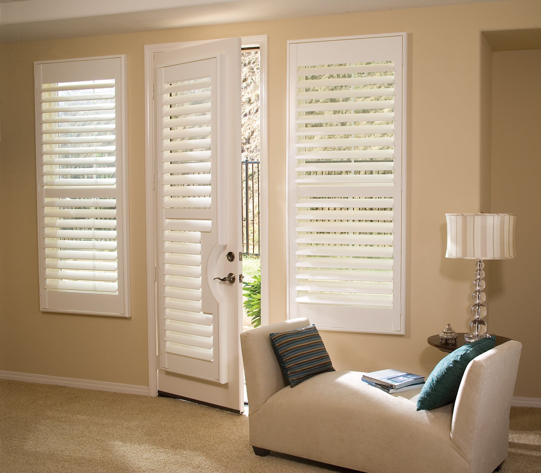 White plantation shutters mounted on a set of French doors in a bright Florida home