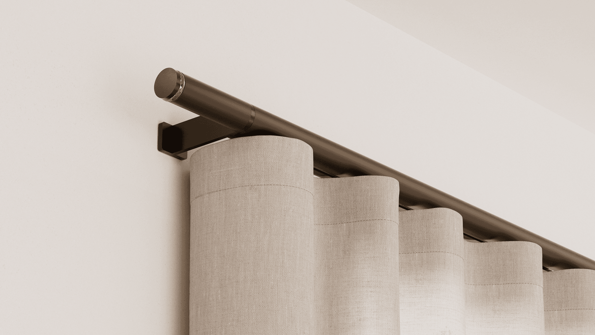 Close-up of a bronze Lutron Palladiom drapery track with a crystal-accented finial and cream ripple-fold linen drapery in even waves