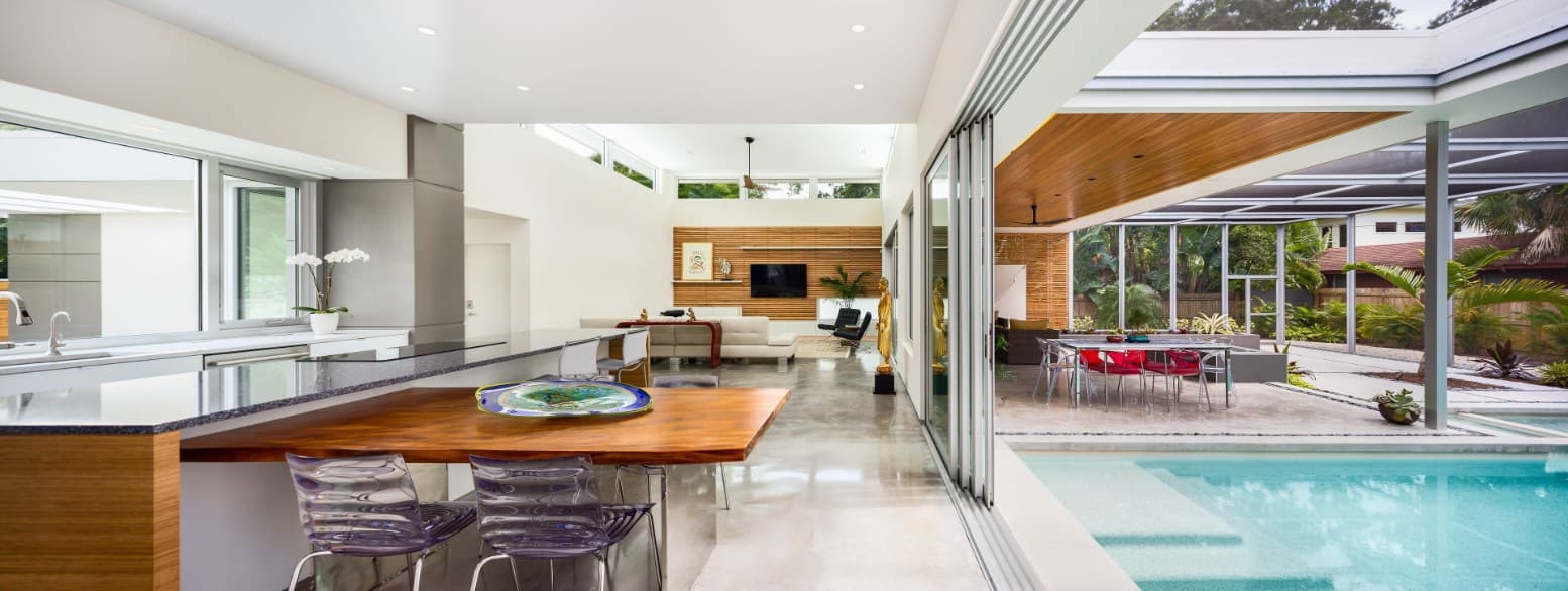 Kitchen opening to a patio through a PGT WinGuard aluminum sliding glass door