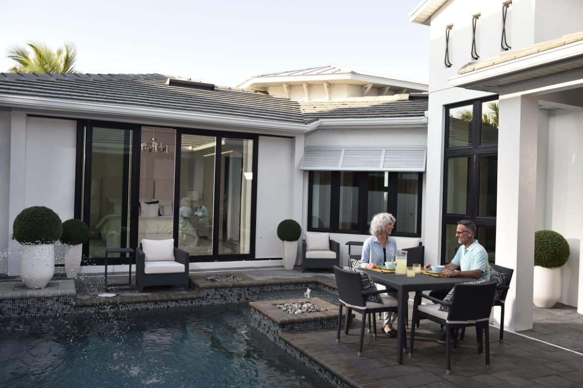Home exterior with PGT WinGuard vinyl sliding glass doors and windows