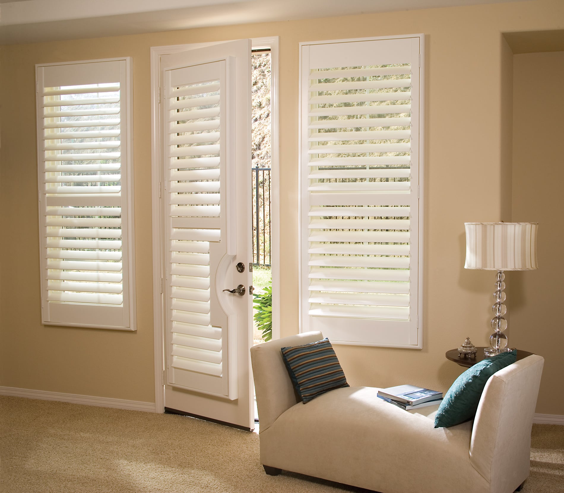 White plantation shutters mounted on a set of French doors in a bright Florida home