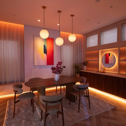 Warmly lit modern dining room at dusk with sheer drapery, Roman-style shades, and cove lighting