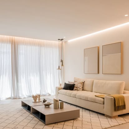Minimal beige living room with white sheer drapery drawn across a full window wall