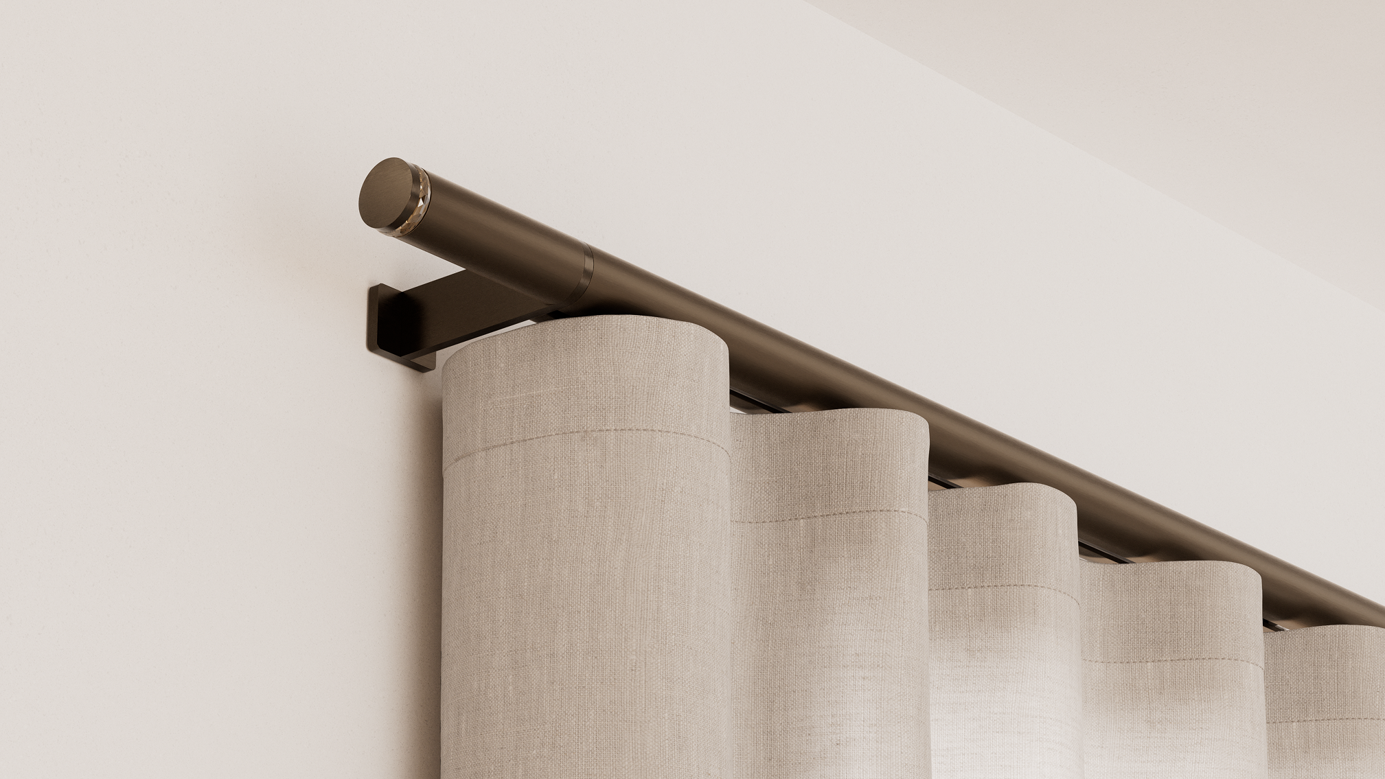 Close-up of a bronze Lutron Palladiom drapery track with a crystal-accented finial and cream ripple-fold linen drapery in even waves