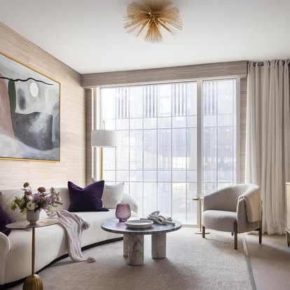 Elegant modern living room with sheer drapery on corner floor-to-ceiling windows and grasscloth walls