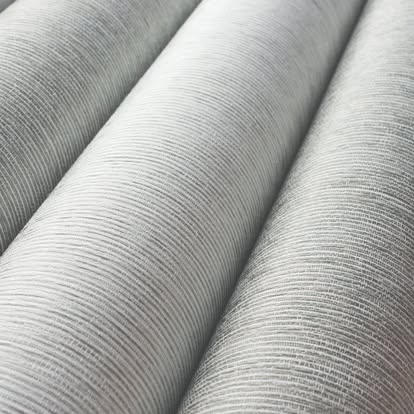 Close-up of rolled gray textured shade fabric showing its fine horizontal weave