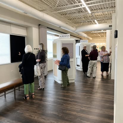 Customers viewing Norman shutter and blind displays in a bright showroom