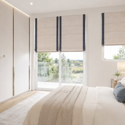 Flat Roman shades with a navy tape border on tall bedroom windows and a sliding glass door