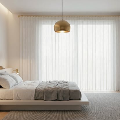 Vertical sheer shades filling a minimalist bedroom with soft, even daylight