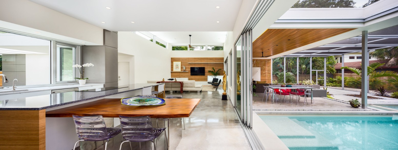 Kitchen opening to a patio through a PGT WinGuard aluminum sliding glass door