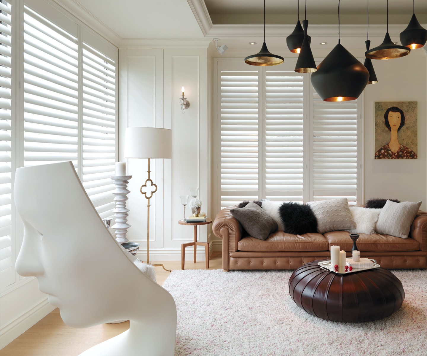 White plantation shutters framing a window beside a room with wood blinds