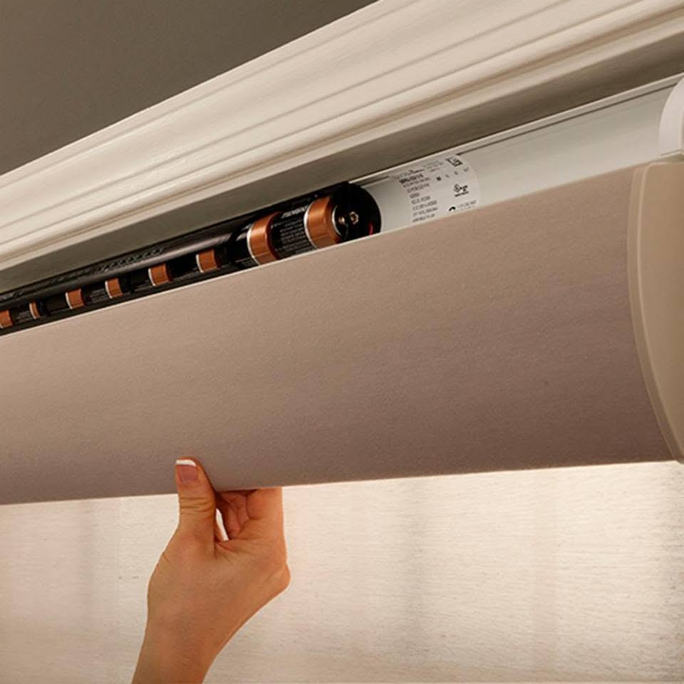 Close-up of a cordless shade being lowered by hand, showing there are no dangling operating cords.
