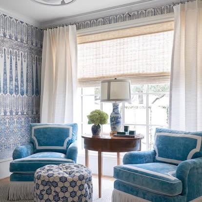 Blue-toned sitting room with natural woven shades, sheers, and patterned wallpaper — product style example